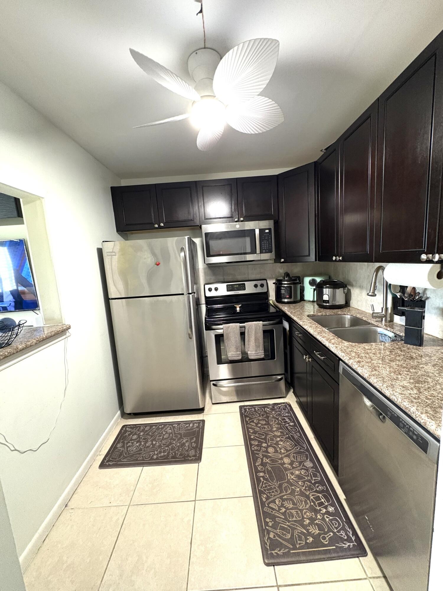 65 Preston F Boca Raton, FL 33434 - Photo 2 of 22 a kitchen with stainless steel appliances granite countertop a refrigerator a sink a stove a microwave and island