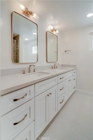 a bathroom with double sink and a mirror