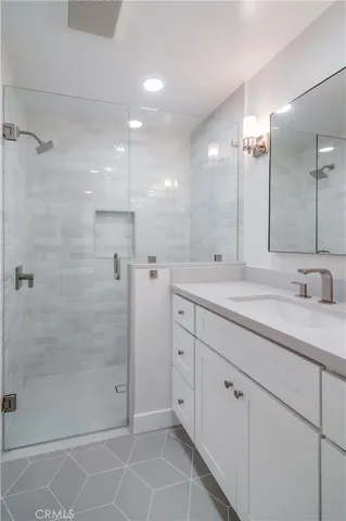 a bathroom with a shower sink and mirror