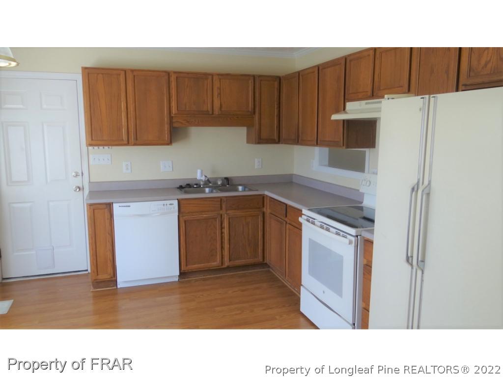 209 Pecan Trace Road Raeford, NC 28376 - Photo 11 of 31 a kitchen with a sink a refrigerator and cabinets