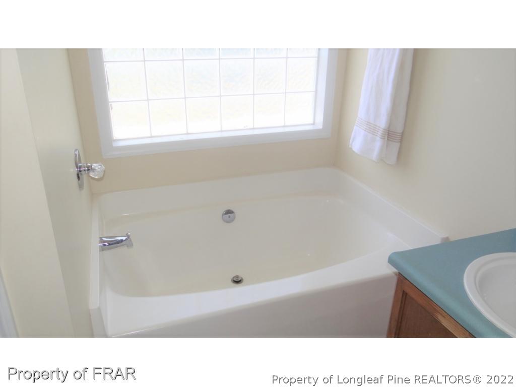 209 Pecan Trace Road Raeford, NC 28376 - Photo 20 of 31 a bathroom with a tub sink and window