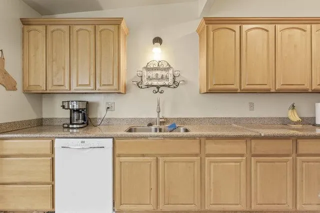 a kitchen with white cabinets and sink