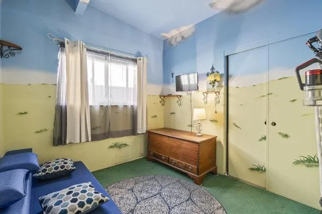 a bedroom with a bed and a refrigerator