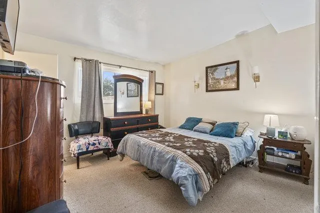 a bedroom with a bed and a lamp on dresser