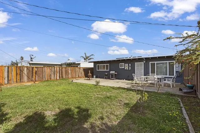 a backyard of a house with table and chairs