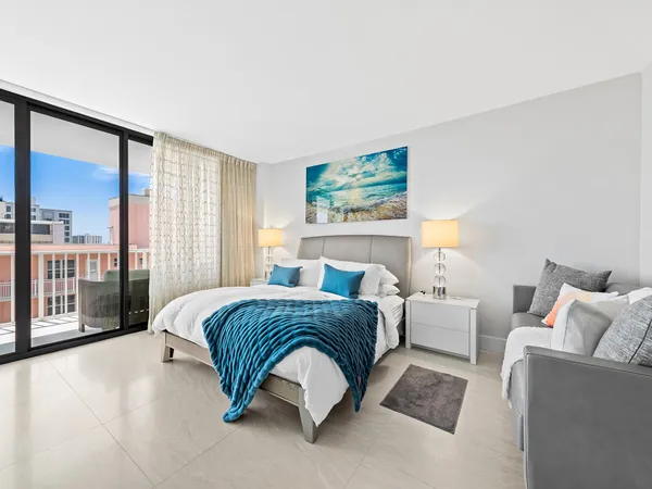 a spacious bedroom with a bed and glass walk in closet