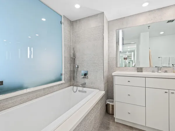 a bathroom with a bathtub a sink a vanity and a shower