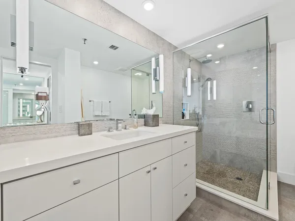 a bathroom with a shower sink and mirror