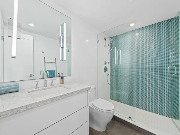 a bathroom with a double vanity sink toilet and shower