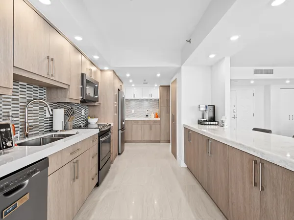 a large kitchen with stainless steel appliances lots of counter space sink and cabinets