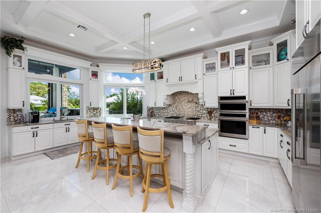 2346 Northwest Fork Road Stuart, FL 34994 - Photo 19 of 100 a kitchen with stainless steel appliances granite countertop a stove top oven a sink a dining table and chairs