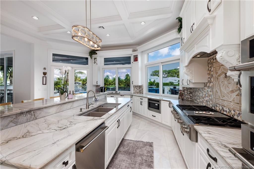 2346 Northwest Fork Road Stuart, FL 34994 - Photo 20 of 100 a kitchen with stainless steel appliances granite countertop a sink a stove and a large window