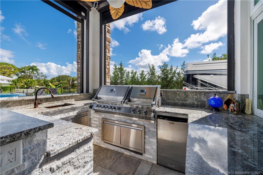 2346 Northwest Fork Road Stuart, FL 34994 - Photo 63 of 100 a open kitchen with stainless steel appliances granite countertop a stove a sink and a microwave