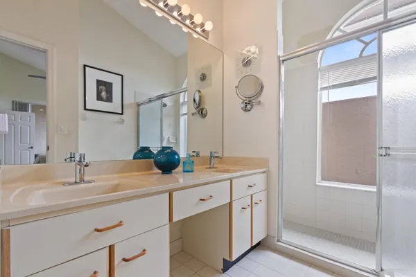 a bathroom with a double vanity sink mirror and shower