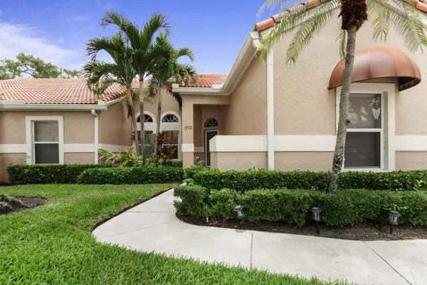 a front view of a house with a yard and potted plants