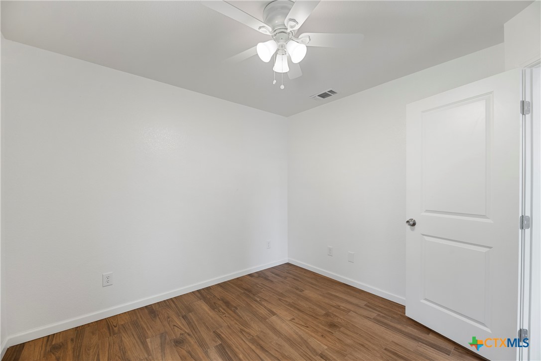 230 Plum Street Luling, TX 78648 - Photo 12 of 33 a view of an empty room with wooden floor