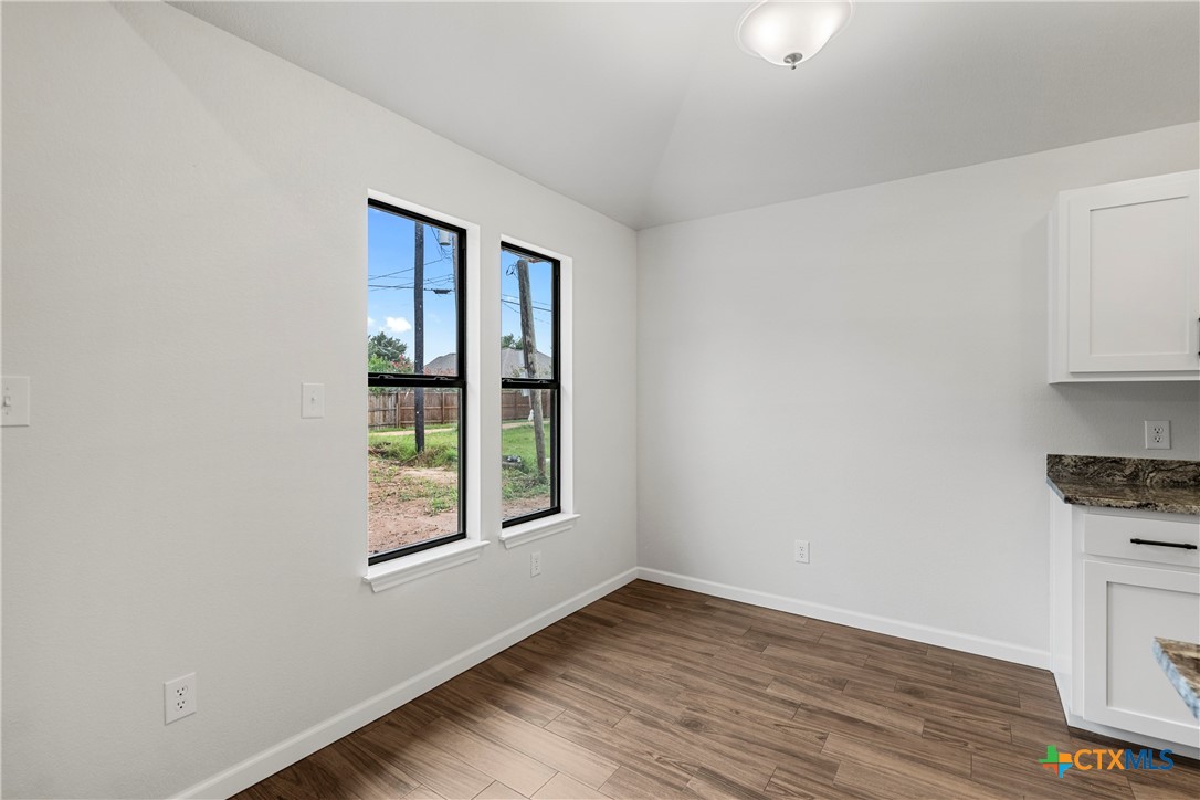 230 Plum Street Luling, TX 78648 - Photo 18 of 33 an empty room with wooden floor and windows