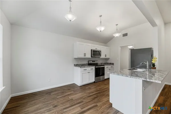 a kitchen with stainless steel appliances a stove top oven a sink and a microwave