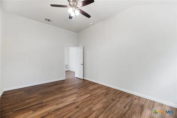 a view of an empty room with wooden floor