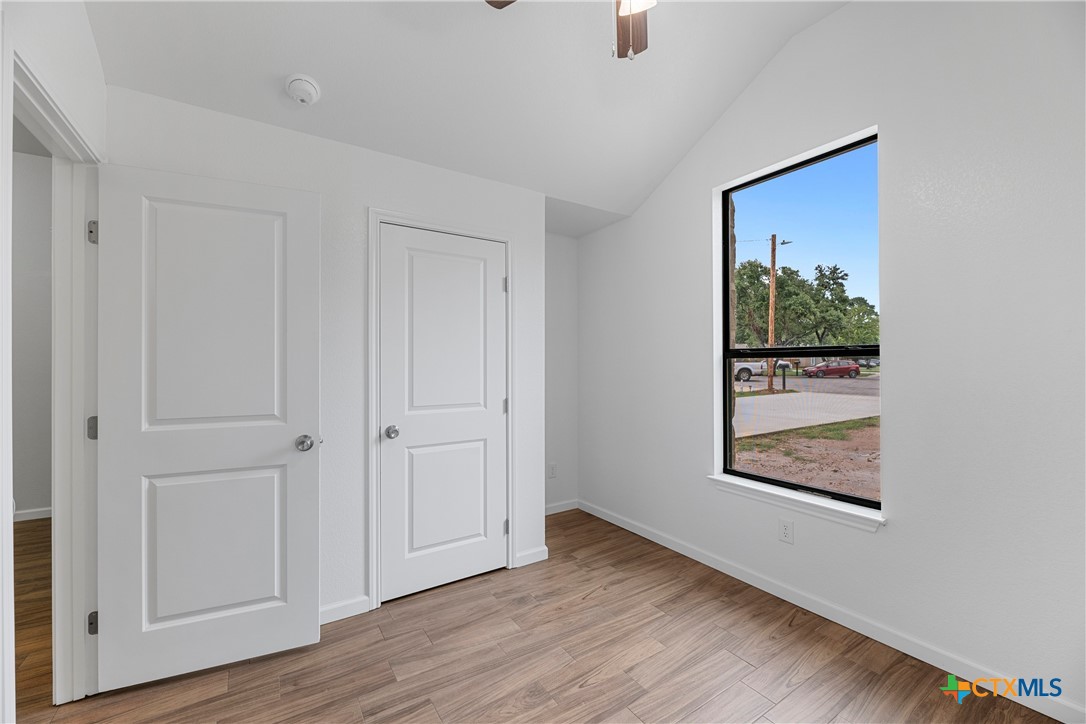 230 Plum Street Luling, TX 78648 - Photo 7 of 33 an empty room with wooden floor closet and windows