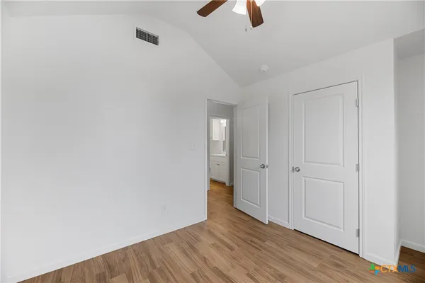 a view of an empty room with wooden floor