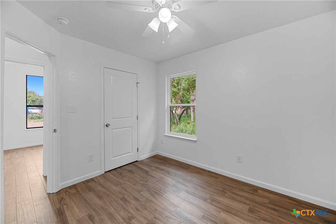 230 Plum Street Luling, TX 78648 - Photo 10 of 33 an empty room with wooden floor closet and windows