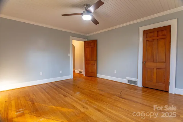 a view of an empty room and window with wooden floor