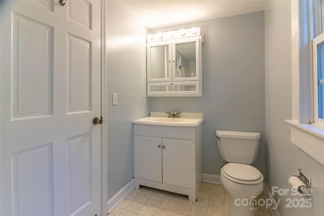 a bathroom with a toilet a sink and mirror