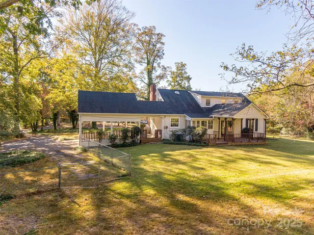 a view of a house with a big yard and large trees