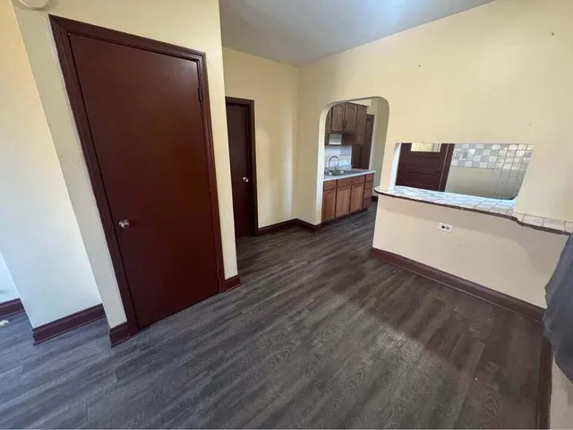 a kitchen with stainless steel appliances granite countertop a refrigerator a stove and a wooden floors