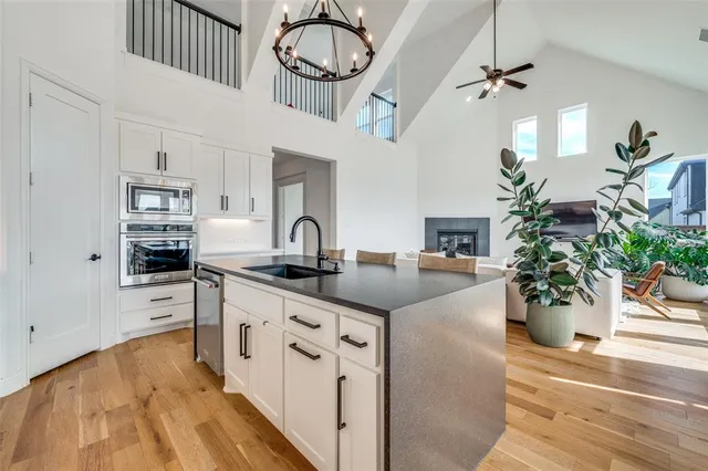 a kitchen with stainless steel appliances granite countertop a stove and a wooden floors