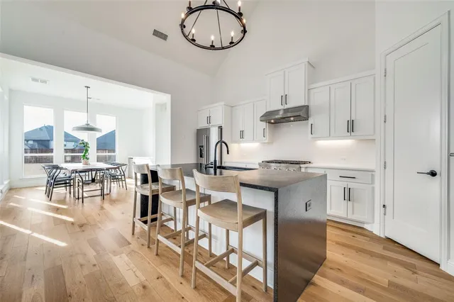 a kitchen with stainless steel appliances a refrigerator a stove a sink and a refrigerator