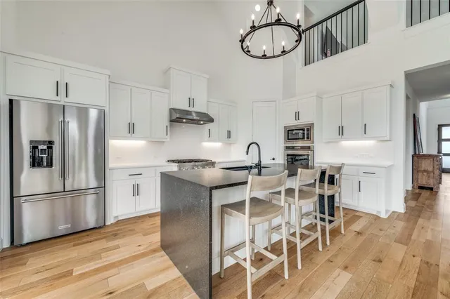 a kitchen with stainless steel appliances a sink stove and cabinets