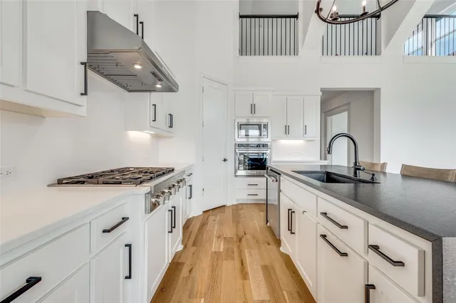 a view of a dining room and livingroom with furniture wooden floor a chandelier