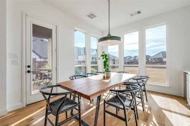 a view of a dining room and livingroom with furniture wooden floor a chandelier