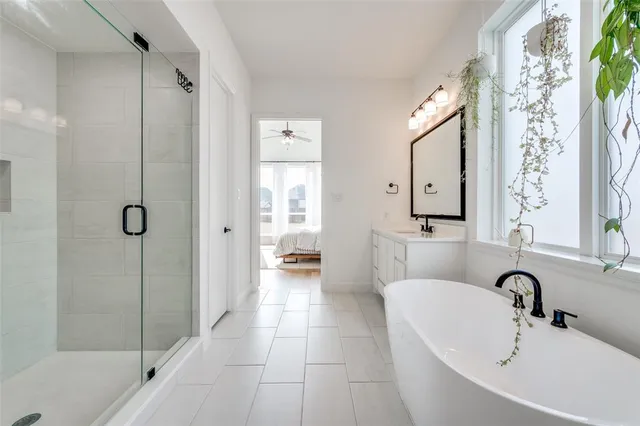 a bathroom with a double vanity sink mirror and bathtub