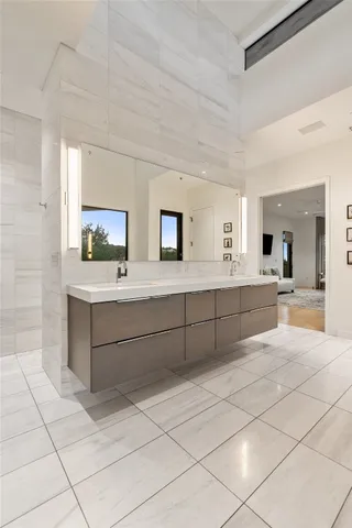 a large white room with a large mirror and cabinets