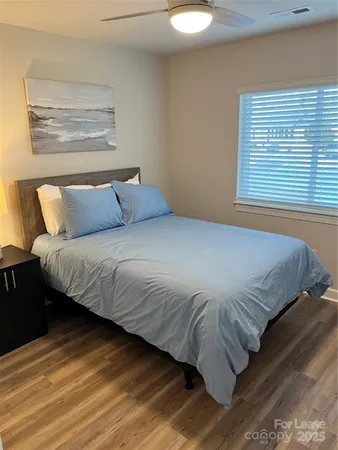 a bedroom with a bed and wooden floor