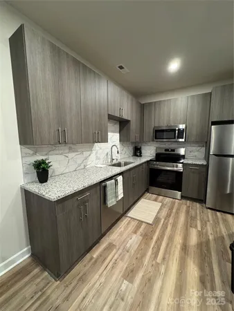 a kitchen with kitchen island wooden cabinets a sink stove and refrigerator