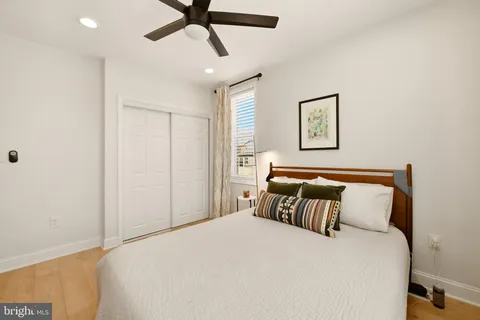 a bedroom with a bed and painting on the wall