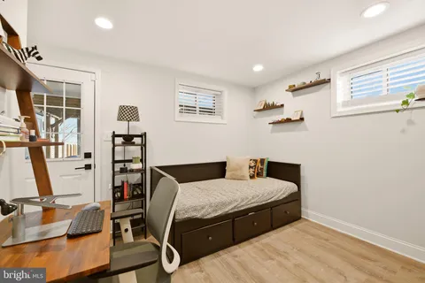 a bedroom with a bed and large windows