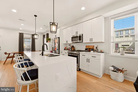 a kitchen that has a sink cabinets counter space and appliances