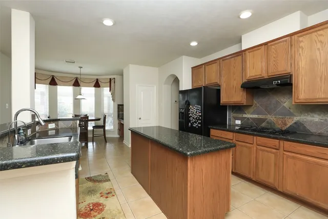 a kitchen with granite countertop a sink a stove and cabinets