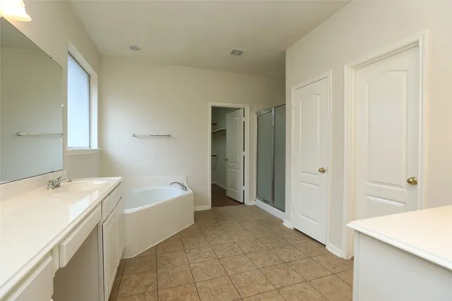 a spacious bathroom with a bathtub sink and mirror