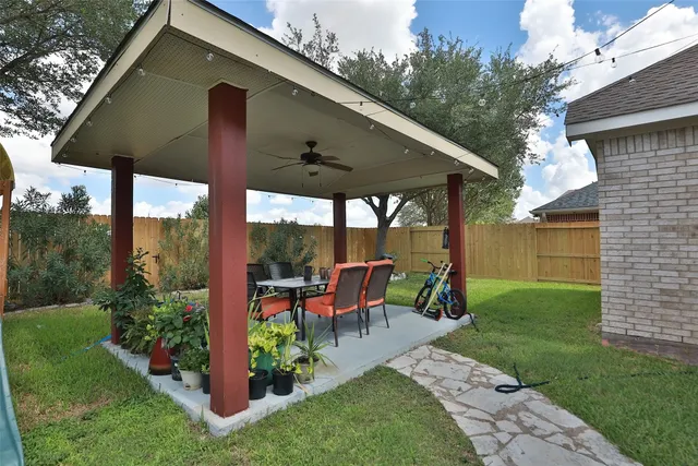a view of a patio with table and chairs potted plants with a large tree