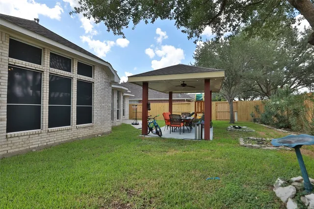 a view of a house with backyard sitting area and garden