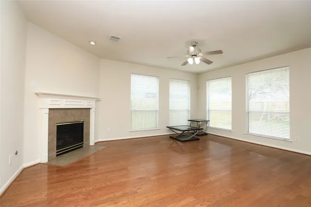 a view of an empty room with a fireplace and a window