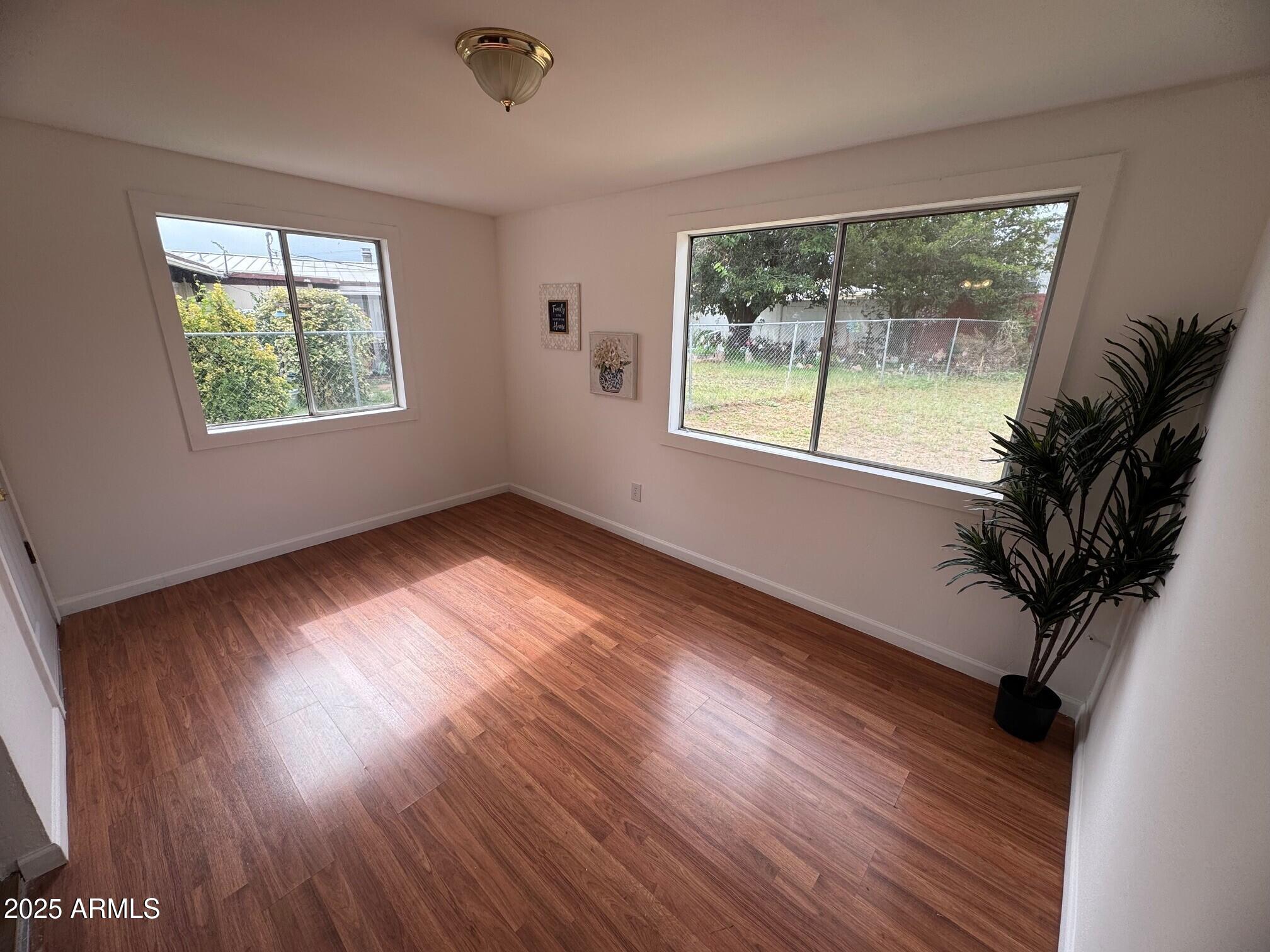 504 Alegre Place Bisbee, AZ 85603 - Photo 10 of 28 a view of an empty room with wooden floor and a window