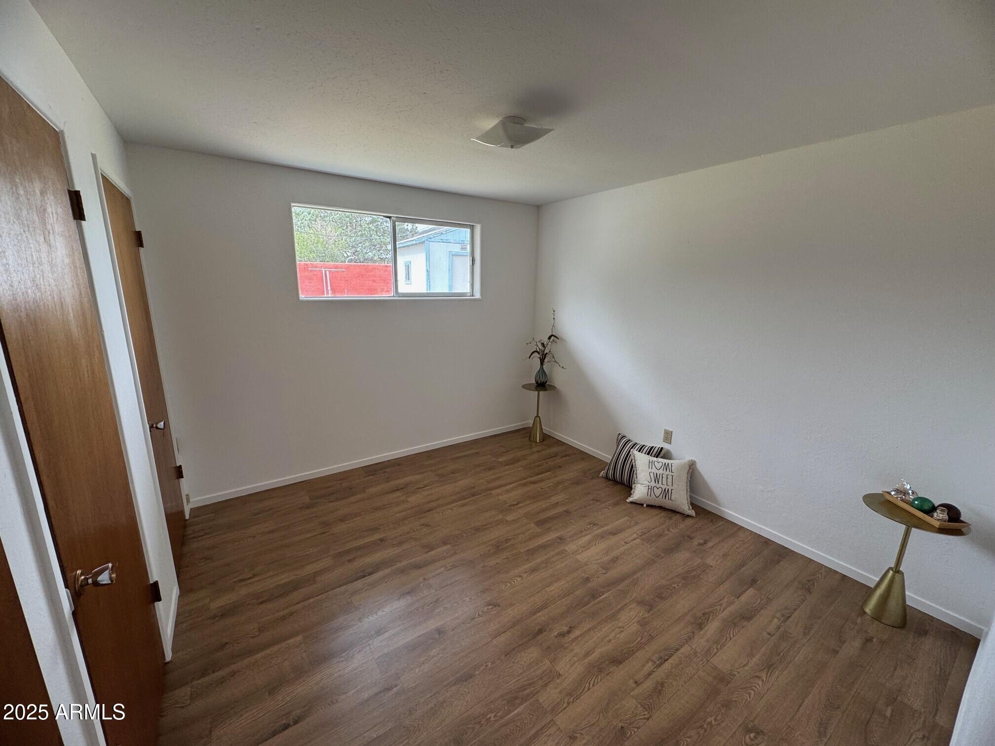 504 Alegre Place Bisbee, AZ 85603 - Photo 17 of 28 an empty room with wooden floor and windows