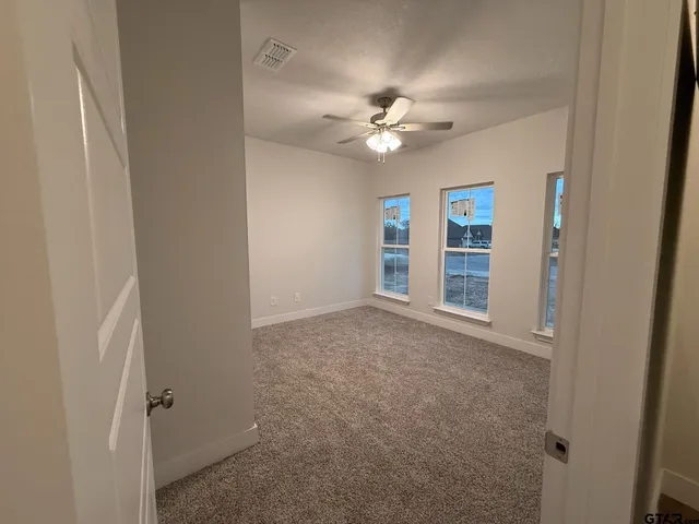 an empty room with closet and fan